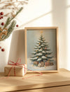 Framed Christmas tree print with presents on a wooden surface next to a wrapped gift.