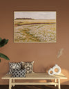 Framed landscape painting on a wall above a wooden bench with decorative pillows and vases.