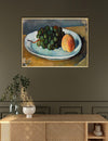 Framed still life painting of grapes and a peach on a plate above a wooden cabinet.