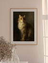 Framed portrait of a cat on a wall with a vase and plant in the foreground