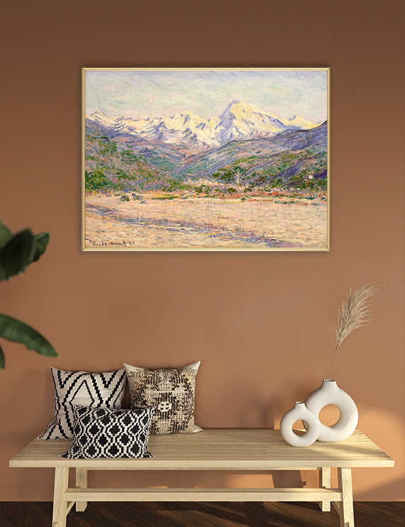 Framed landscape painting on a wall above a wooden bench with decorative pillows and vases.