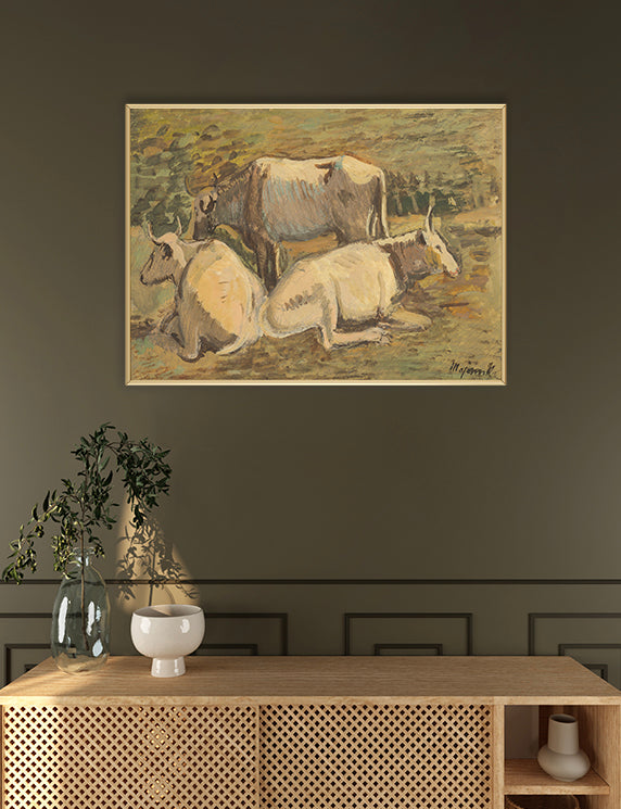 Framed artwork of cows on a wall above a wooden console table.