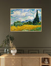 Framed Van Gogh painting of a landscape with a cypress tree on a wall above a wooden console table.