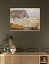 Framed painting of a coastal scene with boats and cliffs on a wall above a wooden console table.