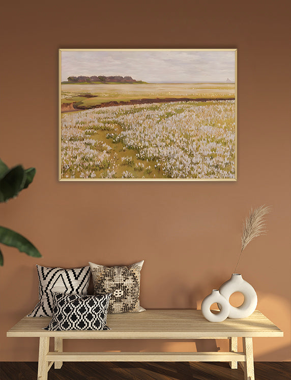 Framed landscape painting on a wall above a wooden bench with decorative pillows and vases.