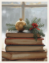 Stack of books with a gold ornament and greenery on a windowsill