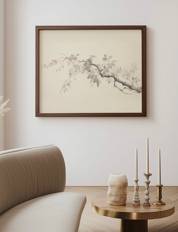 Framed artwork of a branch on a wall above a sofa and side table with decorative items.