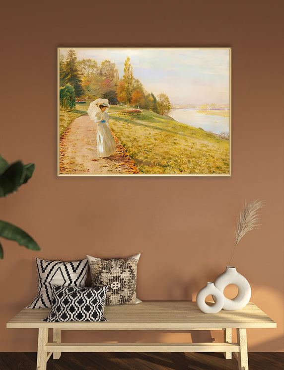 Framed landscape painting on a wall above a wooden bench with decorative pillows and vases.