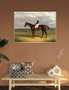 Framed painting of a horse and jockey on a wall above a wooden bench with decorative pillows and vases.
