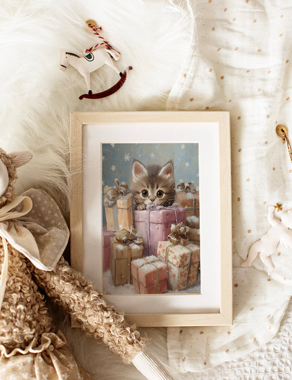 Framed picture of a kitten among presents on a soft, textured surface